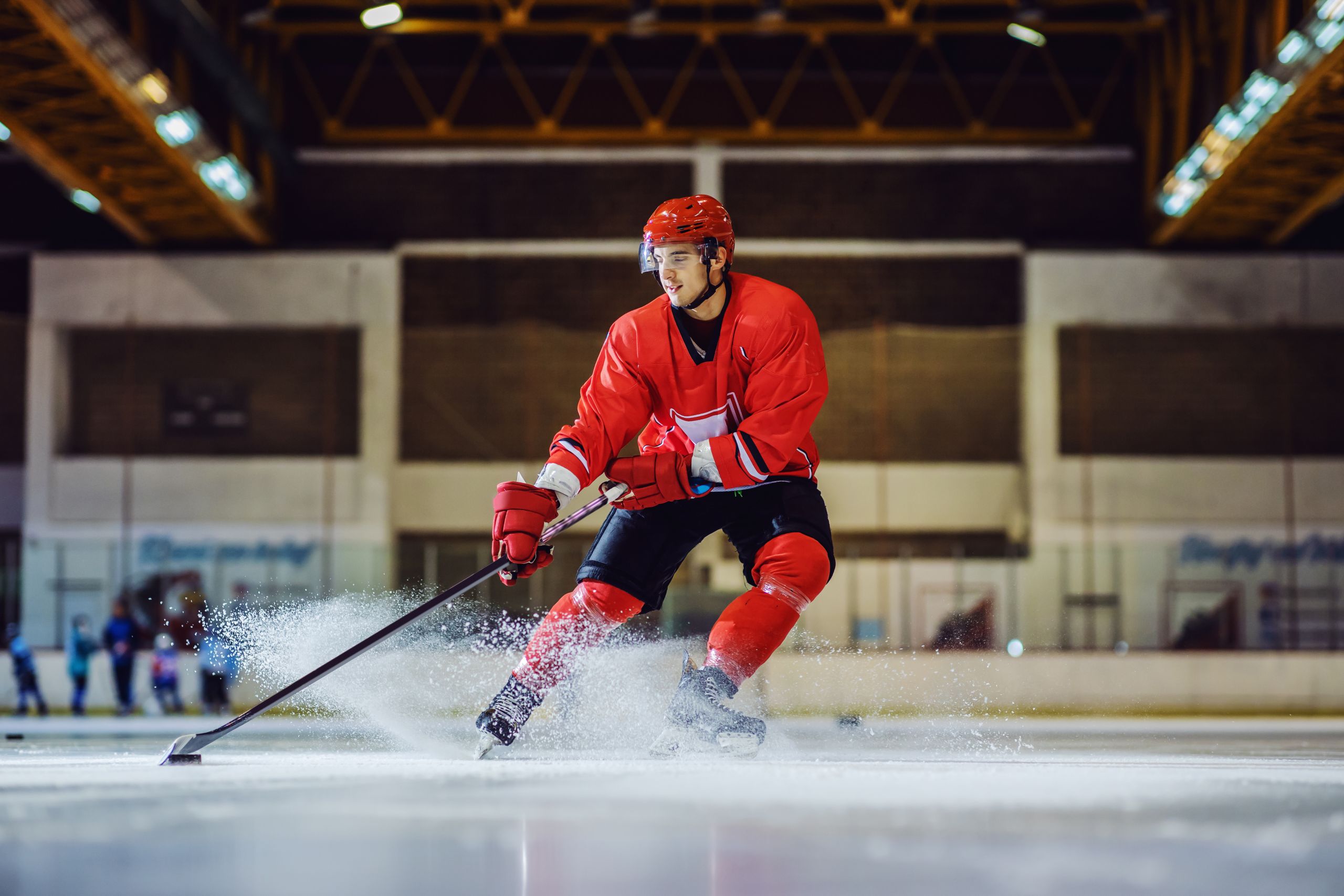 Full length of fearless hockey player skating towards goal and trying to make a score. Hall interior. Winter sports.